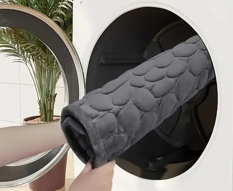 Tapis de bain enroulé devant une machine à laver