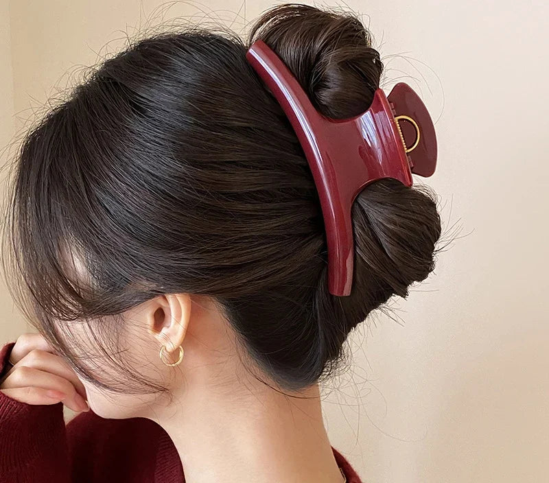Chignon retenu par la grande pince à cheveux bordeaux