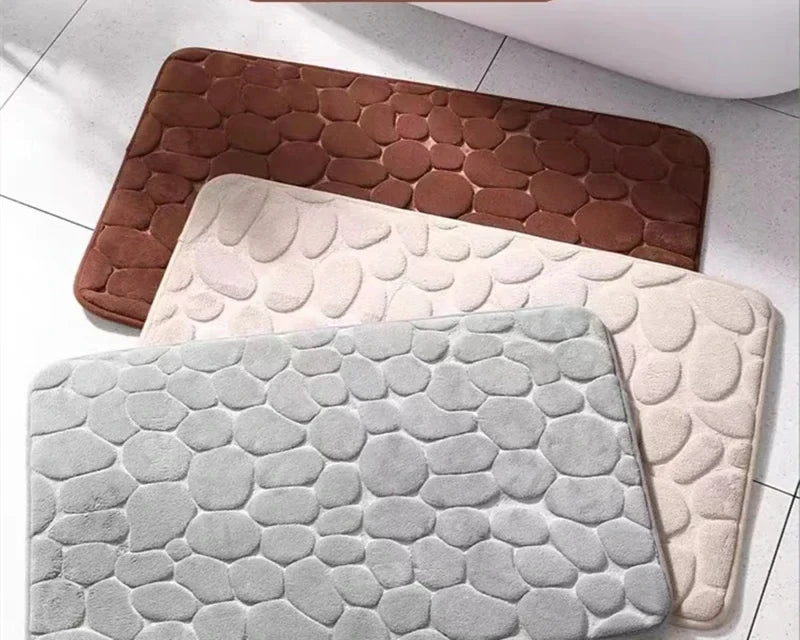 Trois tapis de bain à motif galets : brun, beige et gris