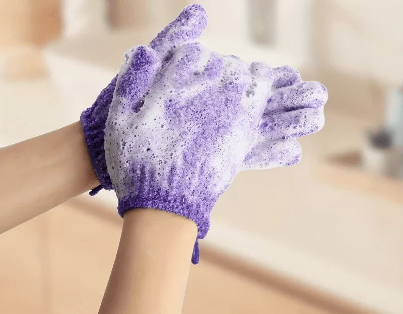 Gant exfoliant violet qui mousse sur le bras