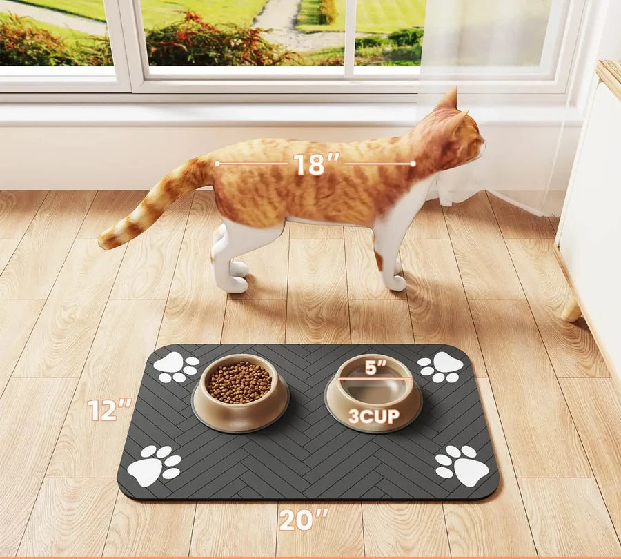 Chat qui mange sur le tapis absorbant posé au sol