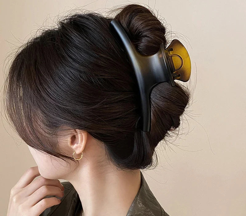 Chignon retenu par la grande pince à cheveux ambre