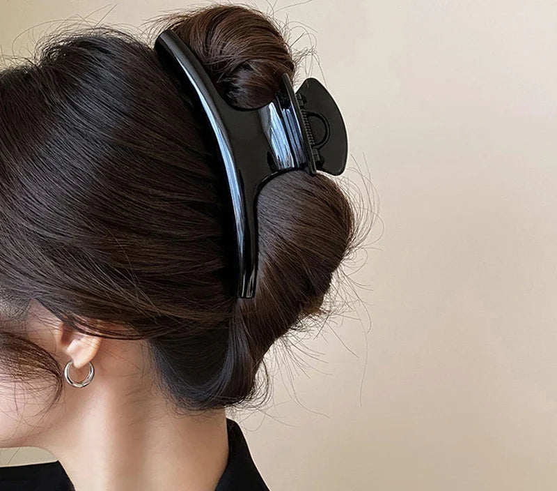 Chignon retenu par la grande pince à cheveux noire, vue de dos