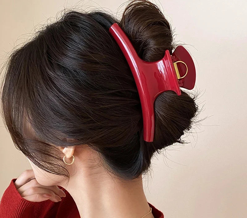 Chignon retenu par la grande pince à cheveux rouge