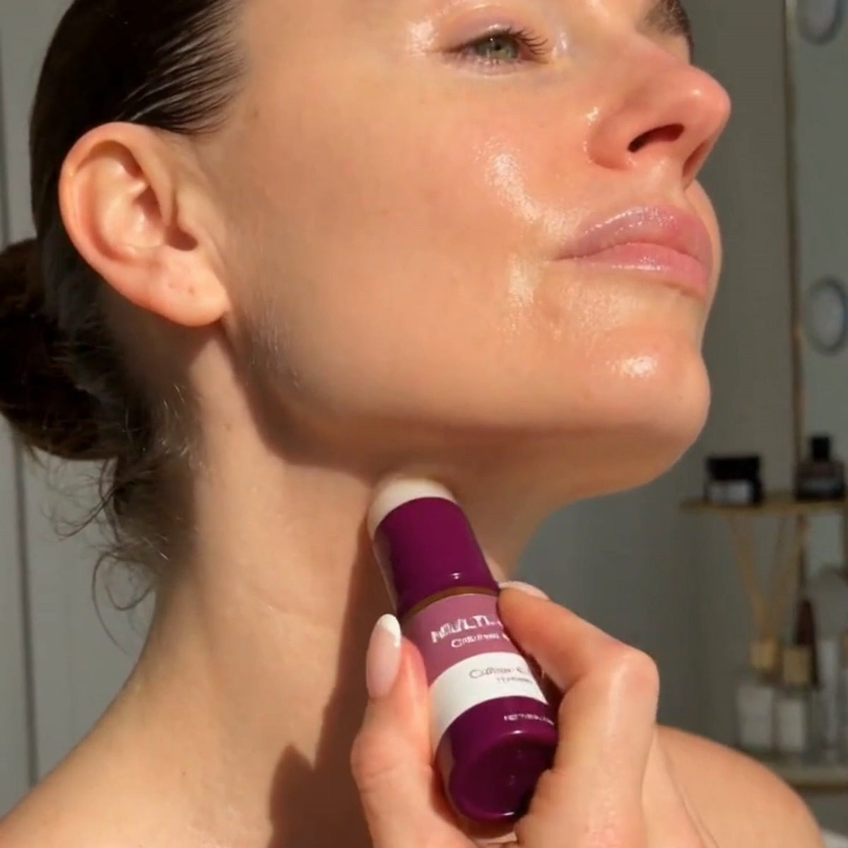 Bâton multi-baume prune glissé sur le cou, de profil